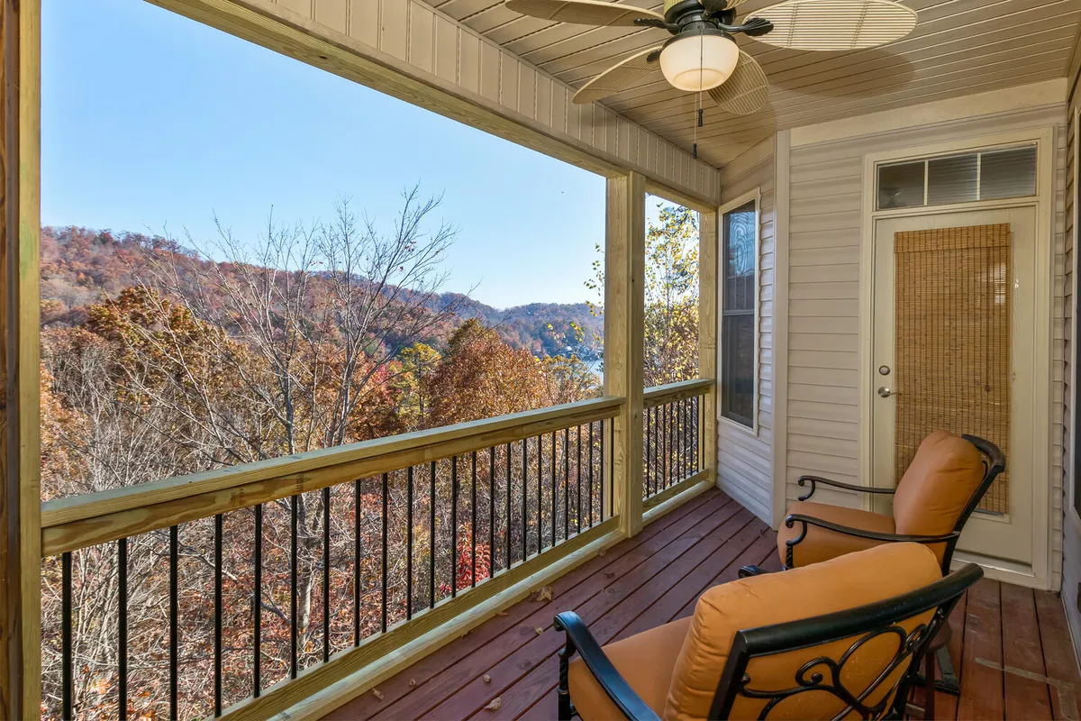 This exterior image features a wooden railing, comfortable chairs, and a stunning mountain view, inviting guests to relax and soak in the peaceful surroundings. The seating area suggests tranquil mornings with coffee or evenings spent listening to the sounds of nature, tying into the theme of wildlife and outdoor enjoyment.